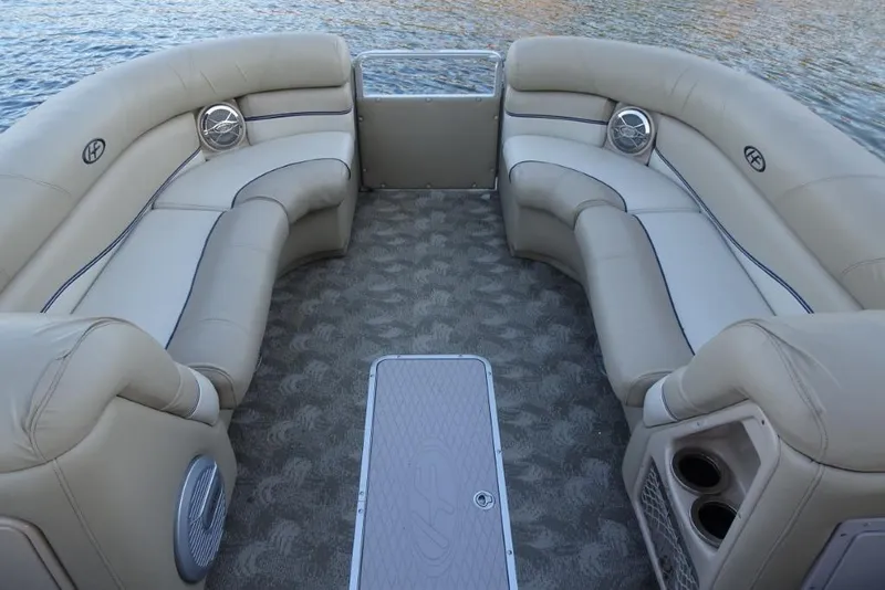 Slide: The Image of 2010 Harris Grand Mariner 230 boat interior with beige seating and water backdrop. - 21