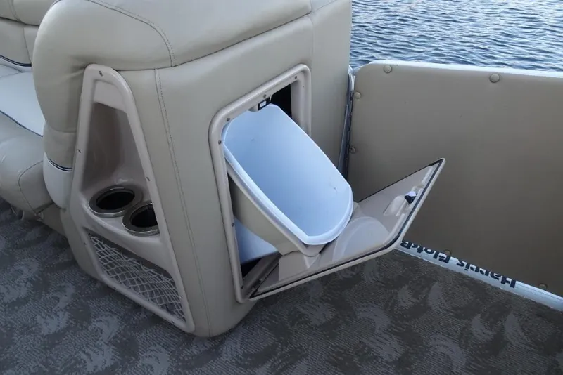 Slide: The Image of 2010 Harris Grand Mariner 230 boat interior with storage compartment and cup holders. - 27