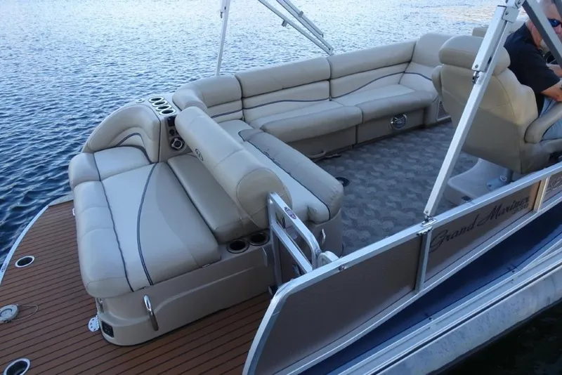 Slide: The Image of 2010 Harris Grand Mariner 230 pontoon boat with beige seating on a calm lake. - 9