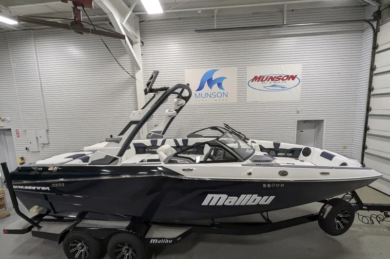 The Image of 2026 Malibu Wakesetter 22 MXZ boat in showroom, side view, on trailer. - 1