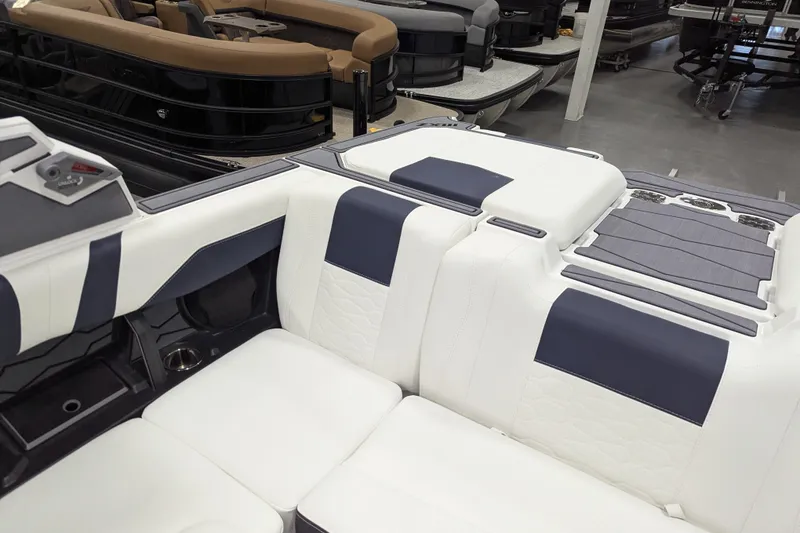 Slide: The Image of 2026 Malibu Wakesetter 22 MXZ interior with white and navy seating in a showroom. - 13