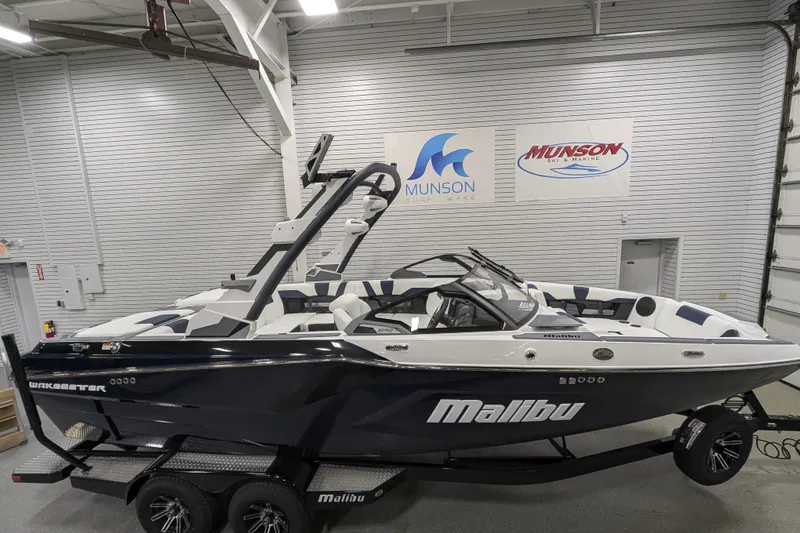 Slide: The Image of 2026 Malibu Wakesetter 22 MXZ boat in showroom, sleek design, Munson Ski & Marine signs. - 21