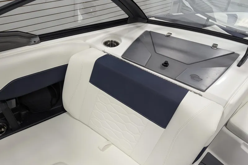 Slide: The Image of 2026 Malibu Wakesetter 22 MXZ interior with white and navy seating, cup holder, and storage compartment. - 8