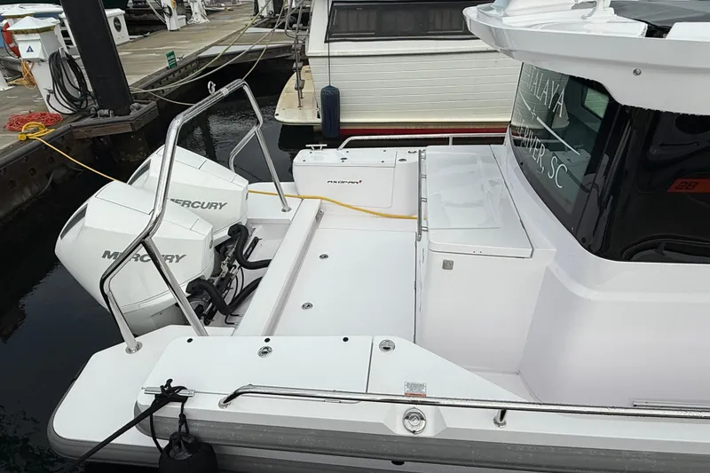 Slide: The Image of 2023 Axopar 28 Cabin Wet Bar boat docked in marina, modern design. - 3