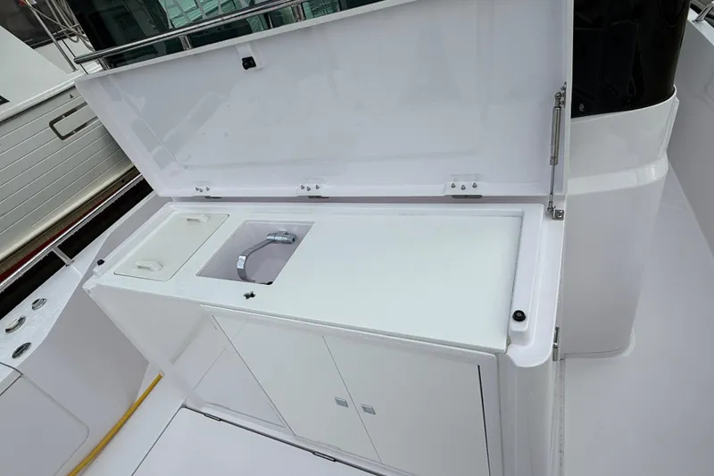 Slide: The Image of 2023 Axopar 28 Cabin Wet Bar boat docked at a marina under clear blue skies. - 4