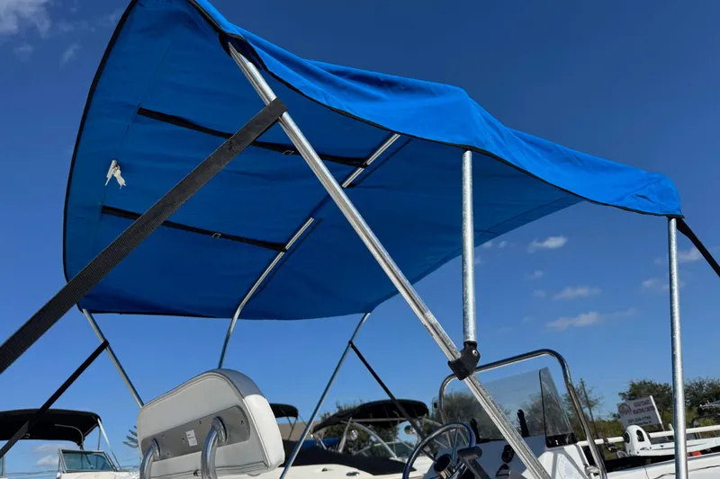 Slide: The Image of 2016 Sportsman Island Bay 20 boat with blue canopy under clear sky. - 4
