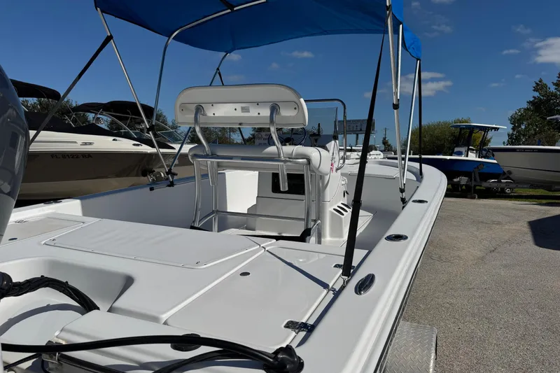 Slide: The Image of 2016 Sportsman Island Bay 20 boat with blue canopy, parked on a trailer under clear skies. - 7