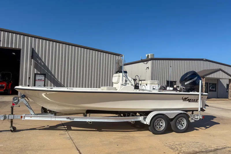Slide: The Image of 2017 Mako 21 LTS boat on trailer, parked outside a metal building. - 11