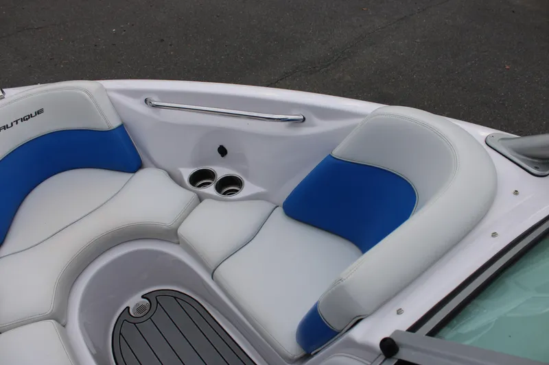 Slide: The Image of 2010 Correct Craft AIR NAUTIQUE SV 211 boat interior with white and blue seating. - 12
