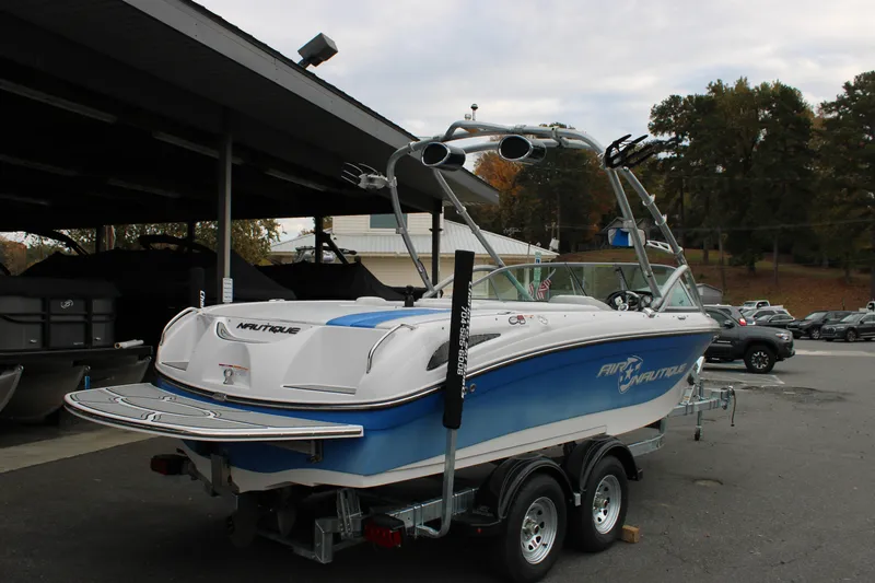 Slide: The Image of 2010 Correct Craft AIR NAUTIQUE SV 211 boat on trailer, parked outdoors. - 4