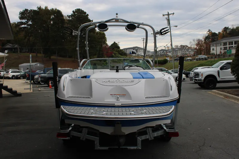 Slide: The Image of 2010 Correct Craft AIR NAUTIQUE SV 211 boat on trailer, rear view in parking lot. - 5
