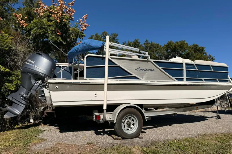 Slide: The Image of 2017 Hurricane FunDeck 196 OB boat on trailer, parked outdoors under clear blue sky. - 2