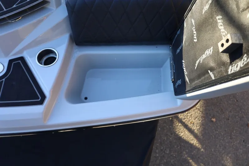 Slide: The Image of 2022 Tigé Z3 boat interior storage compartment with cup holder and black upholstery. - 15