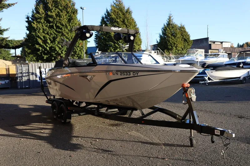 Slide: The Image of 2022 Tigé Z3 boat on trailer, parked outdoors with other boats in background. - 7