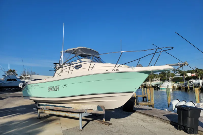 The Image of 2008 Cobia 236 Walk Around boat docked at marina under clear blue sky. - 0