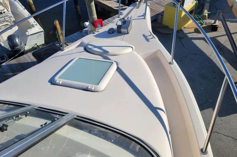 Slide: The Image of 2008 Cobia 236 Walk Around boat deck with hatch and railing at dock. - 4