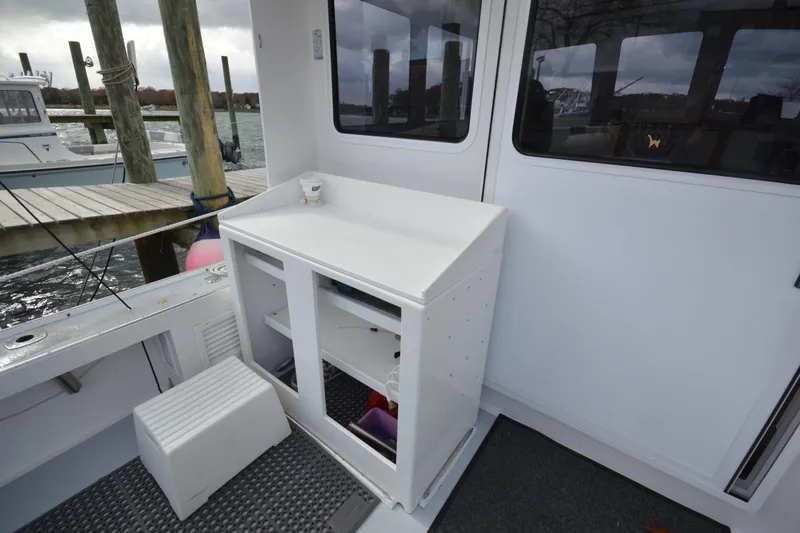 Slide: The Image of 2008 Wayne Beal EXPRESS boat interior with white cabinetry and dock view. - 15