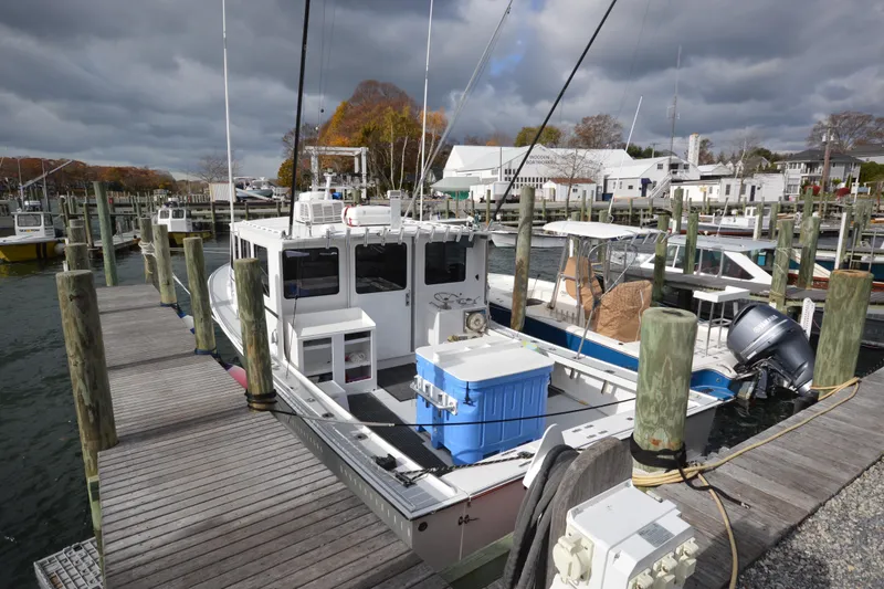 Slide: The Image of 2008 Wayne Beal EXPRESS boat docked at a marina under cloudy skies. - 2