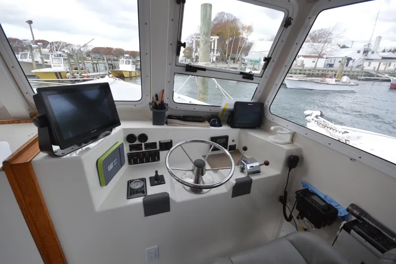Slide: The Image of 2008 Wayne Beal EXPRESS boat cockpit with steering wheel and navigation equipment. - 27