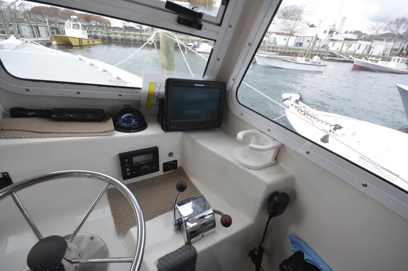 Slide: The Image of 2008 Wayne Beal EXPRESS boat cockpit with steering wheel, navigation equipment, and harbor view. - 31