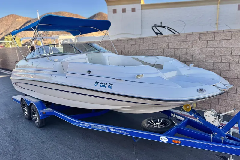 Slide: The Image of 2004 Glastron DX 235 Deckboat on blue trailer, parked outdoors. - 1