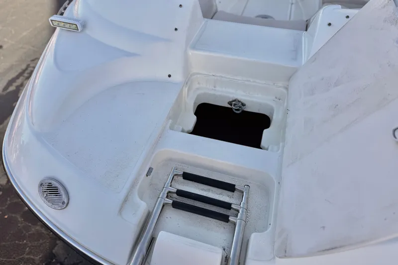 Slide: The Image of 2004 Glastron DX 235 Deckboat with open storage compartment and retractable ladder. - 11