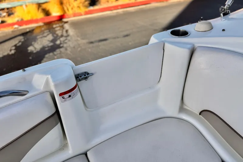 Slide: The Image of 2004 Glastron DX 235 Deckboat interior detail with white seating and cup holder. - 17