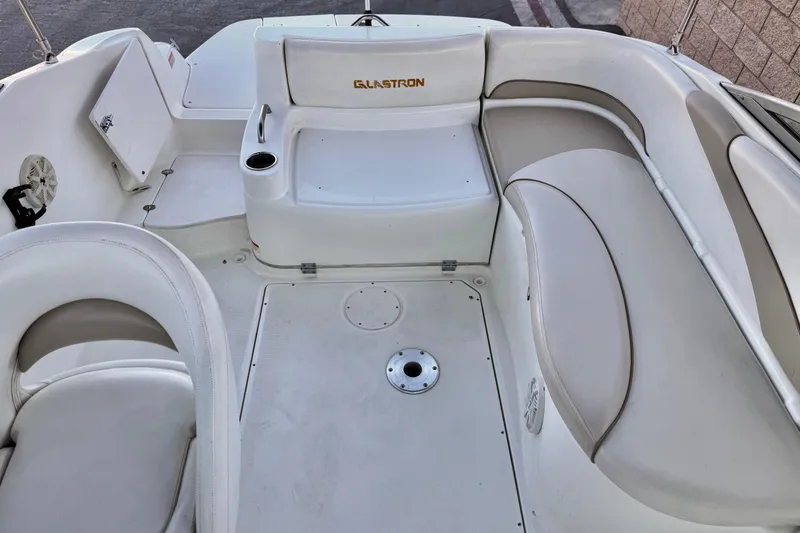 Slide: The Image of 2004 Glastron DX 235 Deckboat interior with white seating and cup holder. - 19