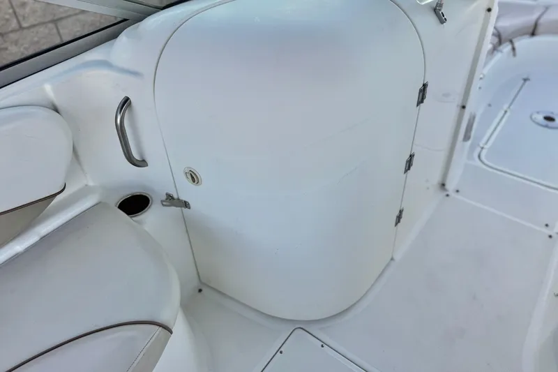 Slide: The Image of 2004 Glastron DX 235 Deckboat interior with white seating and storage compartment. - 22