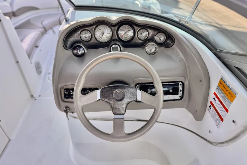 Slide: The Image of 2004 Glastron DX 235 Deckboat dashboard with steering wheel and gauges. - 27