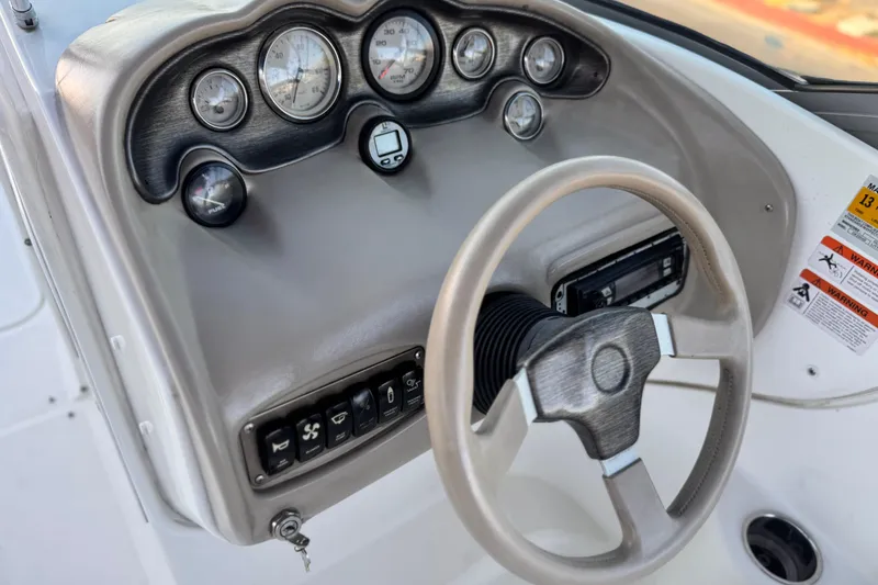 Slide: The Image of 2004 Glastron DX 235 Deckboat dashboard with steering wheel and instrument panel. - 28