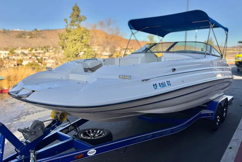 Slide: The Image of 2004 Glastron DX 235 Deckboat on trailer with blue canopy, parked outdoors. - 3