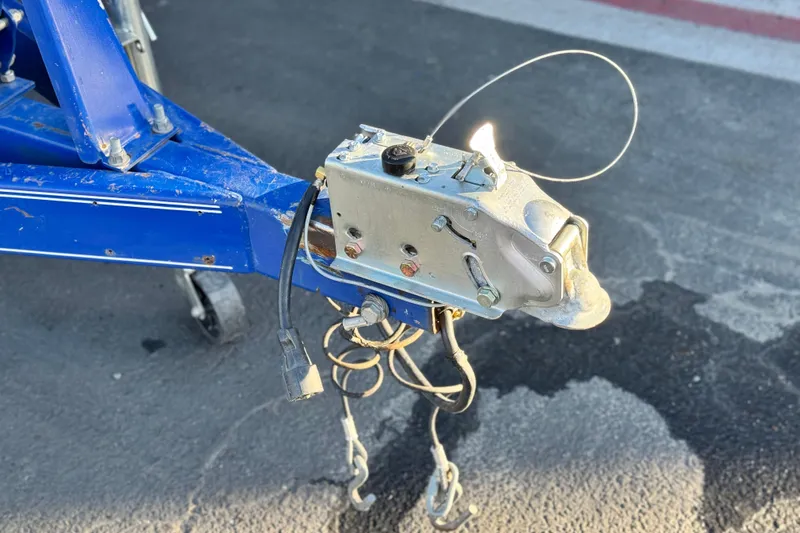 Slide: The Image of Trailer hitch of a 2004 Glastron DX 235 Deckboat on asphalt surface. - 30