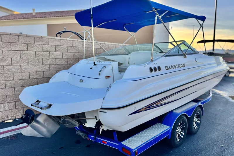 Slide: The Image of 2004 Glastron DX 235 Deckboat with blue canopy on a trailer. - 5
