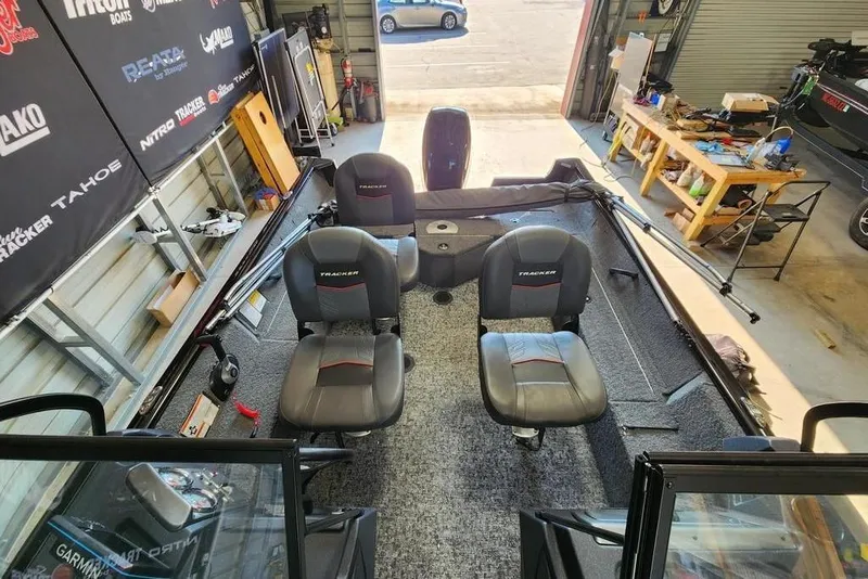 Slide: The Image of 2025 Tracker Pro Guide V-16 WT boat interior with seating and equipment in a garage. - 10