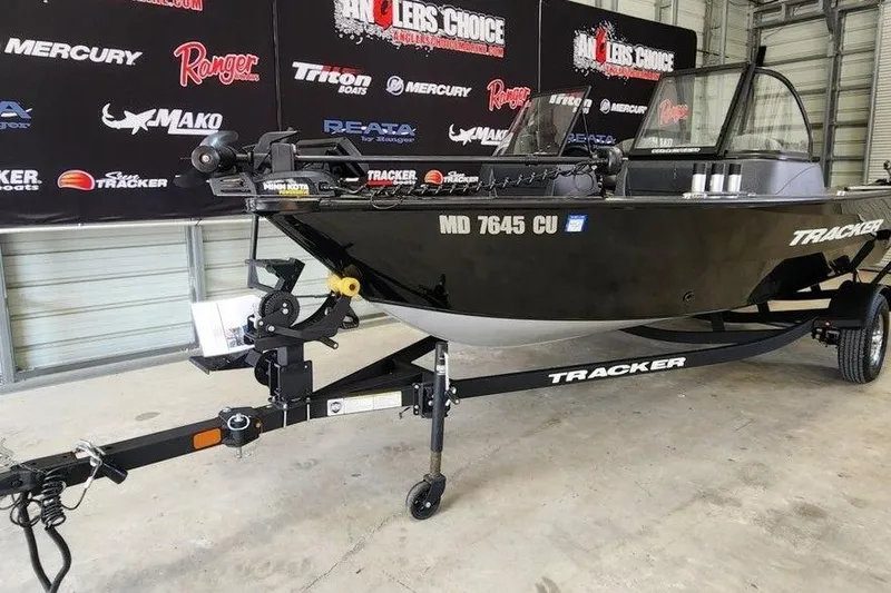 Slide: The Image of 2025 Tracker Pro Guide V-16 WT boat on trailer in showroom setting. - 5