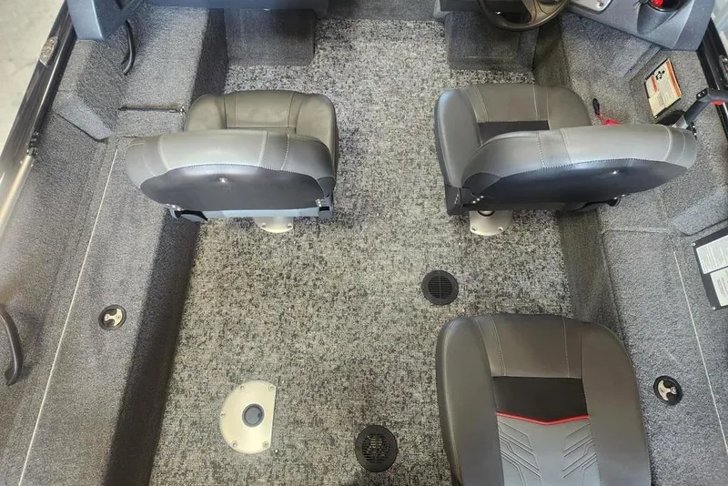 Slide: The Image of 2025 Tracker Pro Guide V-16 WT boat interior with gray seating and carpeted flooring. - 6