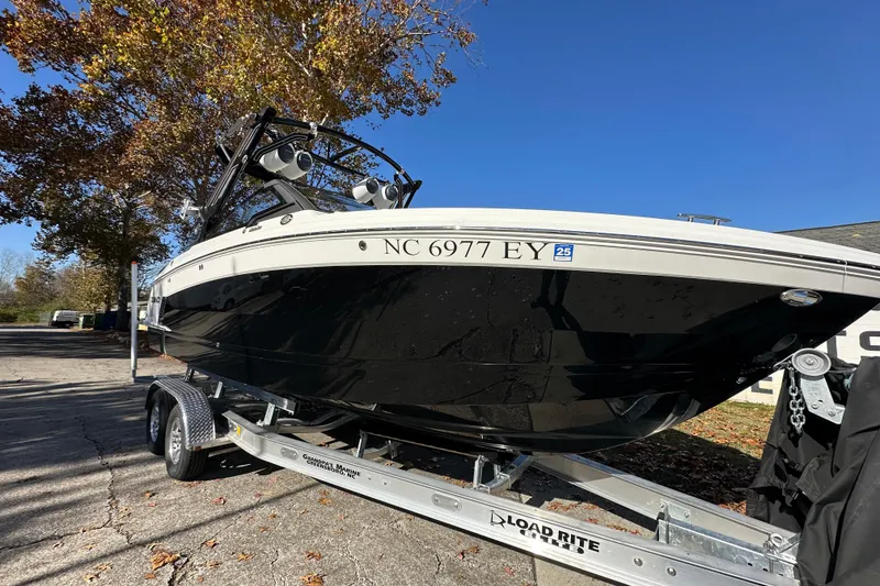 The Image of 2023 Cobalt R6 Surf boat on trailer, parked under clear blue sky. - 0