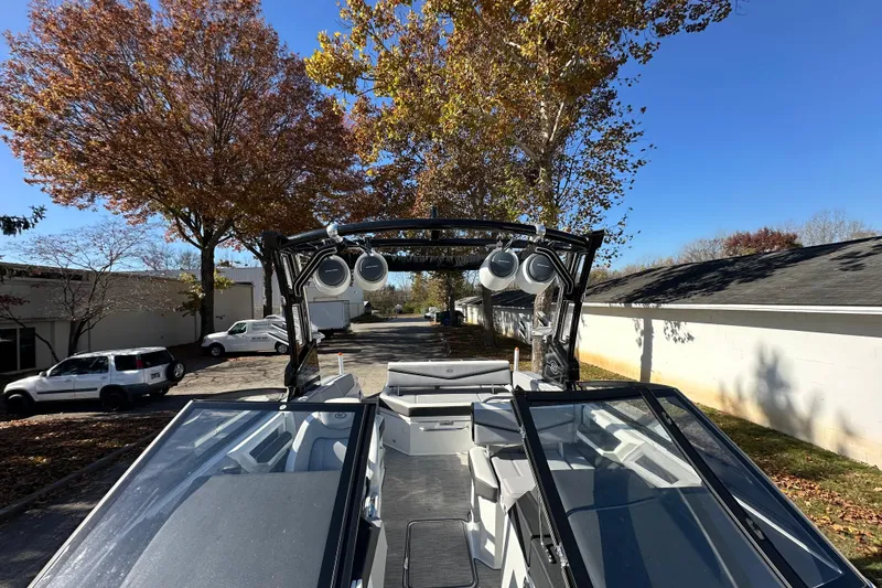 Slide: The Image of 2023 Cobalt R6 Surf boat with sleek design, parked outdoors under clear blue sky. - 11