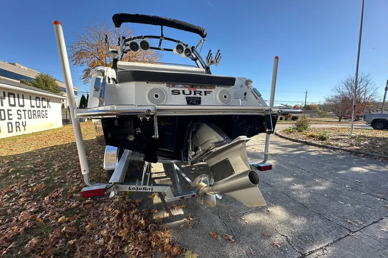Slide: The Image of 2023 Cobalt R6 Surf boat on trailer, rear view with propeller, outdoors. - 2