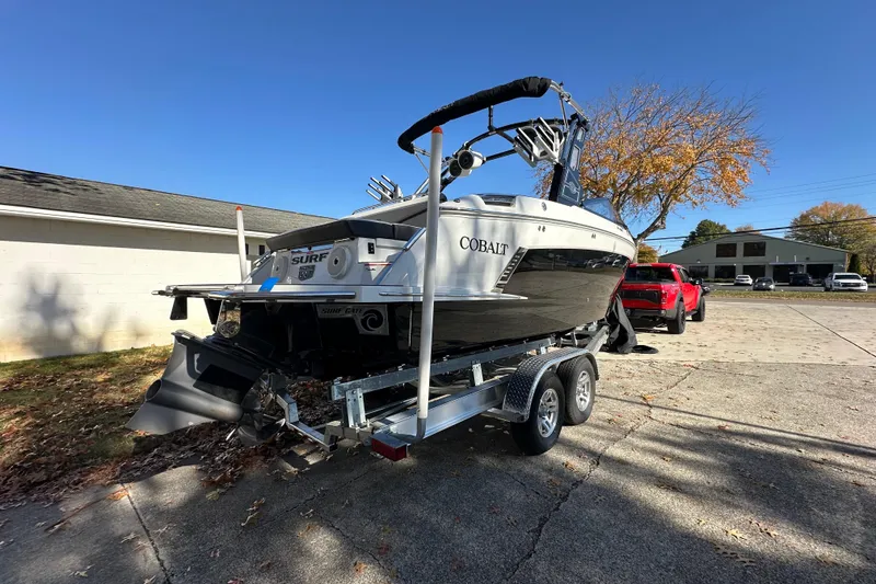 Slide: The Image of 2023 Cobalt R6 Surf boat on trailer, parked outdoors on a sunny day. - 4