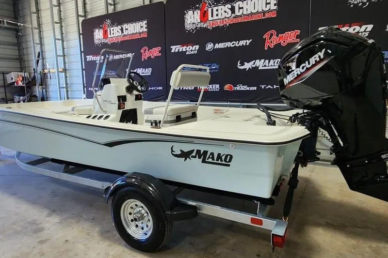 Slide: The Image of 2026 Mako Pro Skiff 17 CC boat with Mercury engine on display in showroom. - 3