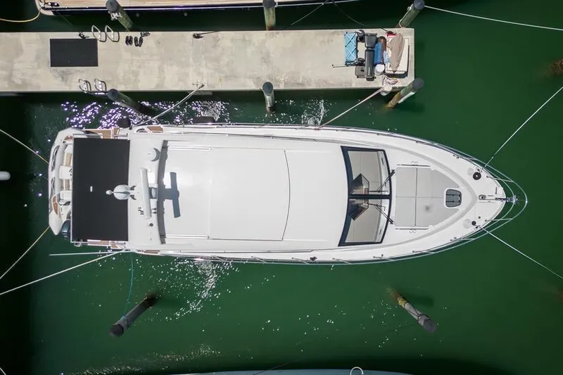 Slide: The Image of Overhead view of a 2017 Sea Ray Sundancer 460 yacht docked in green water. - 103