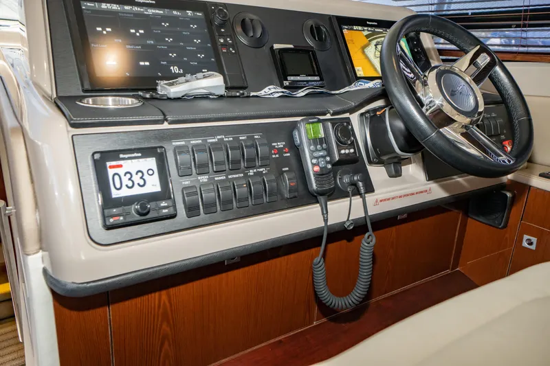 Slide: The Image of 2017 Sea Ray Sundancer 460 helm with advanced navigation controls and steering wheel. - 11
