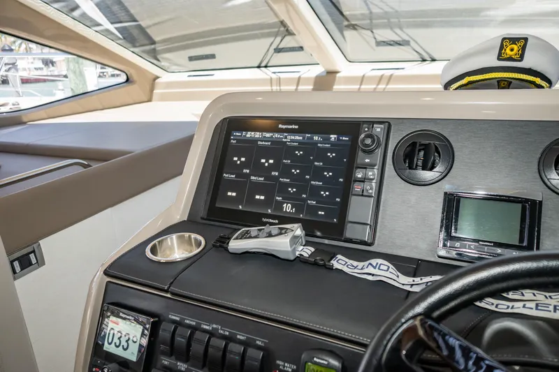 Slide: The Image of 2017 Sea Ray Sundancer 460 helm with navigation display and captain's hat. - 13