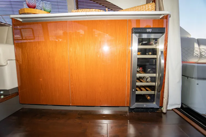 Slide: The Image of Luxurious interior of 2017 Sea Ray Sundancer 460 with wine cooler and wooden cabinetry. - 28