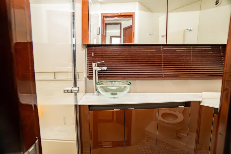 Slide: The Image of Luxurious bathroom in 2017 Sea Ray Sundancer 460 yacht with glass sink and wooden accents. - 57