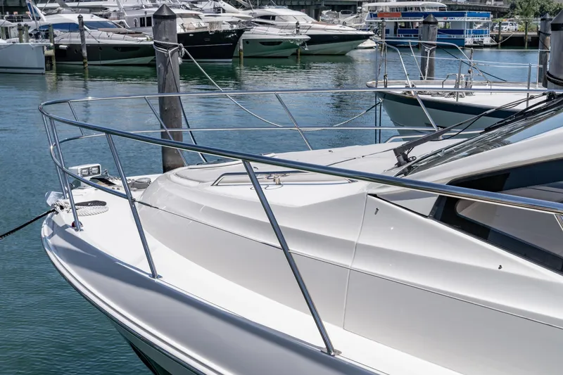 Slide: The Image of 2017 Sea Ray Sundancer 460 yacht docked in a marina, surrounded by other boats. - 99