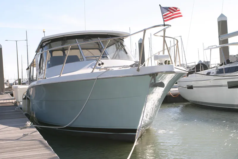 Slide: The Image of 1996 Hatteras 39 Sport Express docked, displaying American flag, in marina setting. - 14