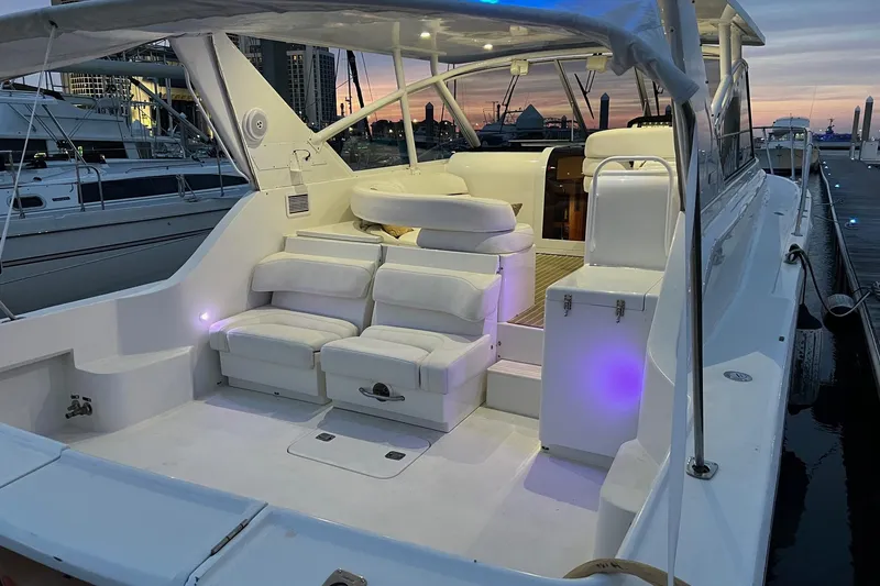 Slide: The Image of 1996 Hatteras 39 Sport Express yacht with white seating, docked at sunset. - 17